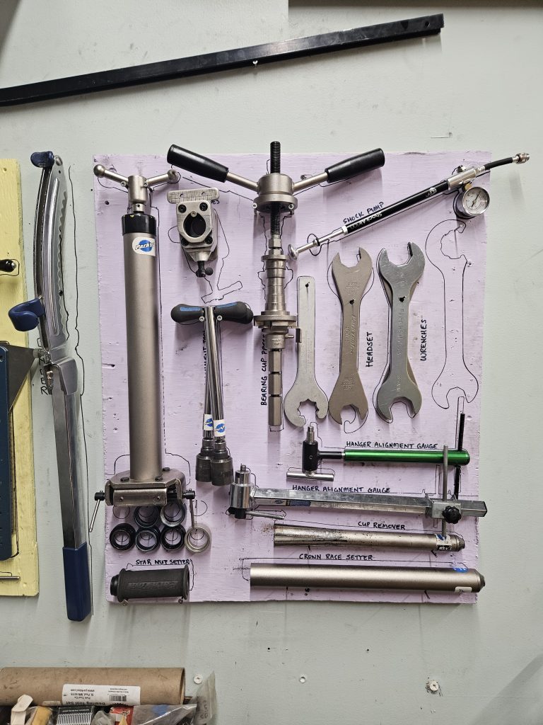 This is the hanger and headset board. It has a crown race remover, headset press, cup remover, star nut sutter and drop out alignment gauges.